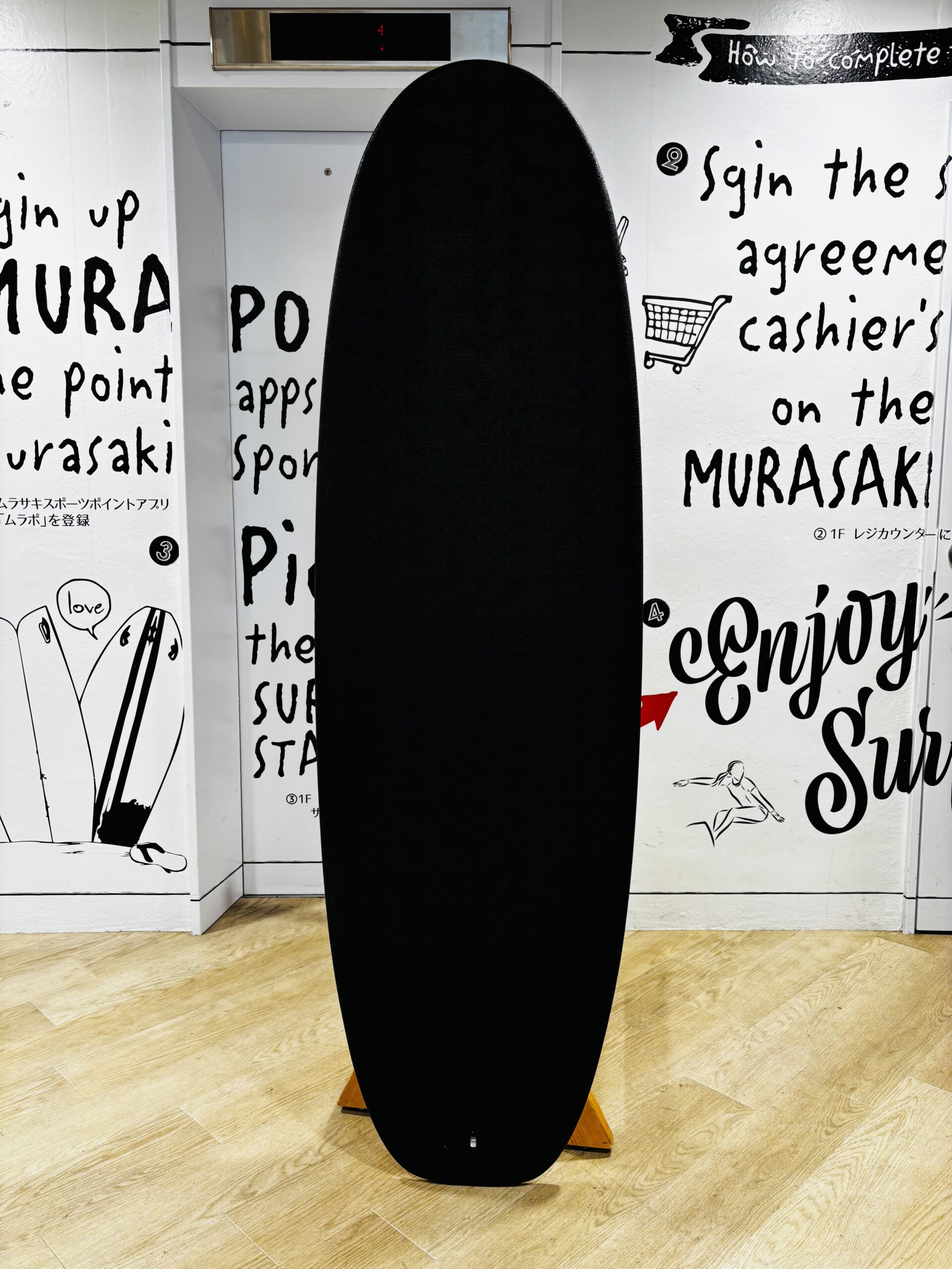 IMG_1145 - SHOP NEWS | ムラサキスポーツオンラインストア 通販 Tall black curved sculpture stands upright in a white gallery with handwritten wall text as background.