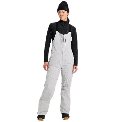 Person modeling light gray ski bib pants over a black long-sleeve top and black beanie, standing with hands at sides.