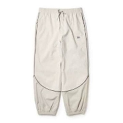 Beige jogger-style pants with a curved seam panel across the legs and elastic cuffs at the ankles.