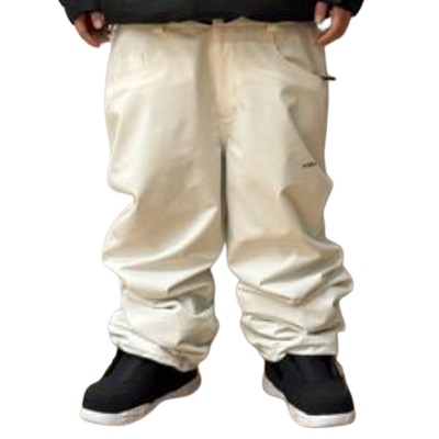 Lower half of a person wearing beige baggy snow pants and black sneakers.
