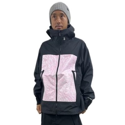 Man standing in a dark windbreaker with pink front panels, zip pockets, and a gray knit beanie, against a white background.