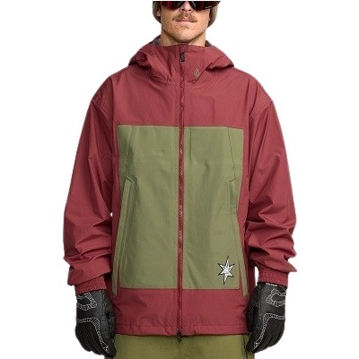 Man wearing a red hooded windbreaker with olive green chest panels and a small white star patch near the lower right pocket.