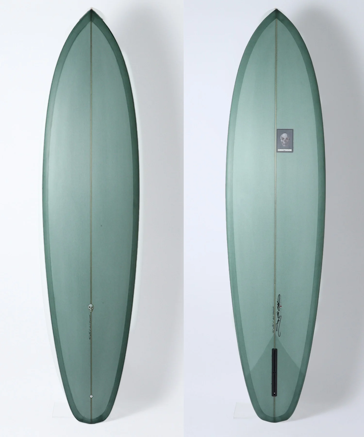 image - SHOP NEWS | ムラサキスポーツオンラインストア 通販 Two vertical teal-green surfboards shown side by side, left plain and right with a small skull-brand sticker reading 'Christenson' mid-length on the board's surface as a reference view pair.