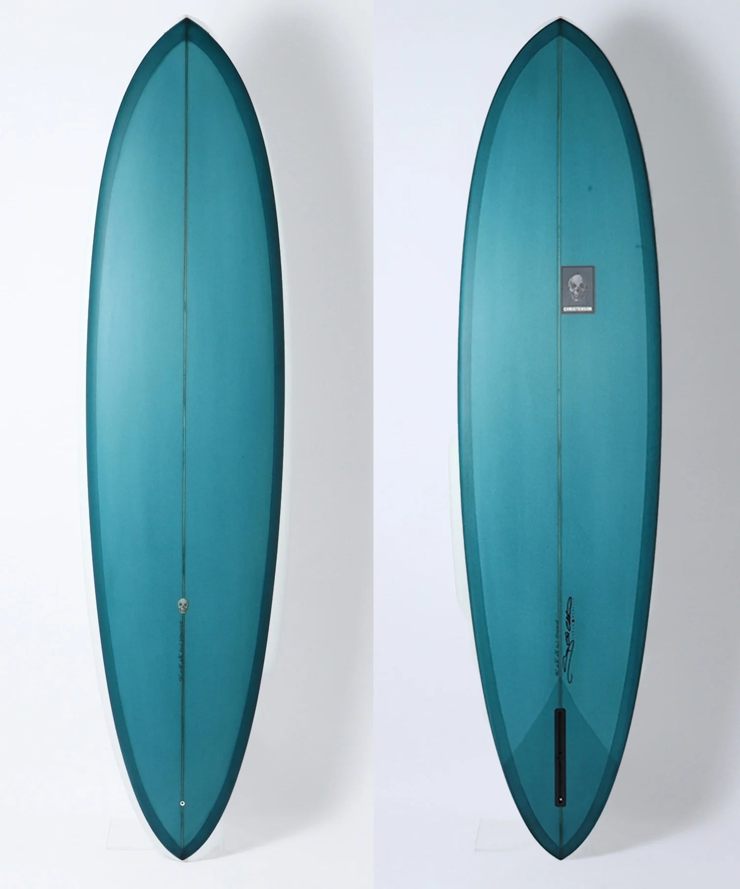 image - SHOP NEWS | ムラサキスポーツオンラインストア 通販 Two teal surfboards shown side by side against a white background; left is a front view, right is the back view with a small logo sticker.