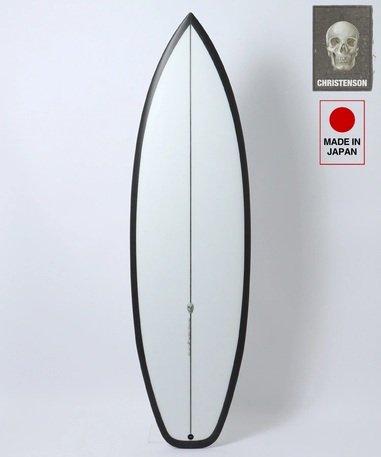 image - SHOP NEWS | ムラサキスポーツオンラインストア 通販 White surfboard with a black edge and center seam, photographed against a light background; brand stickers in the top-right corner (skull image and 'Made in Japan').