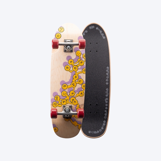 Two skateboards placed side by side: a wooden deck with yellow floral design and purple accents, and a black grip-taped deck on the right.