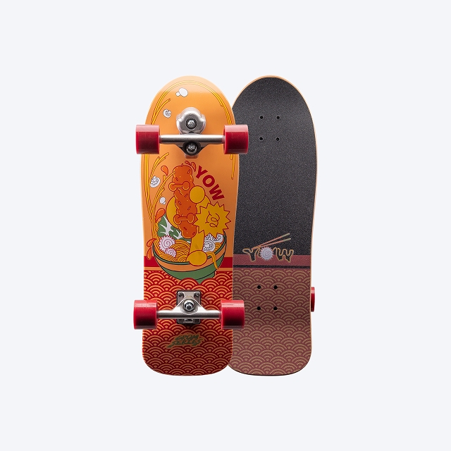 Two skateboards standing side by side, left one with orange graphic and red wheels, right one with dark grip tape and brown wave pattern.