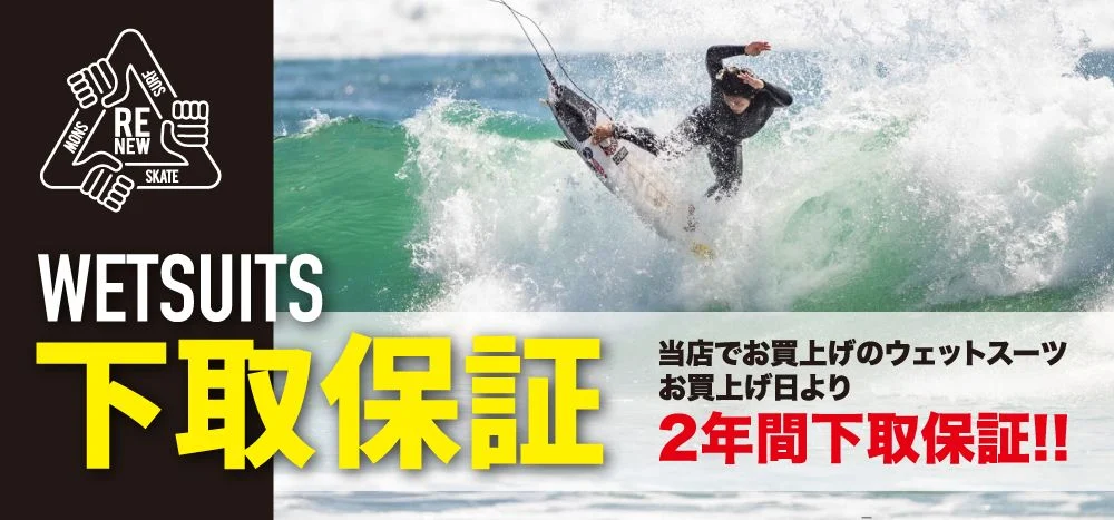 Surfing action on a green wave in a wetsuits ad, with bold 'WETSUITS' text and large yellow Japanese characters plus a 2‑year guarantee claim.
