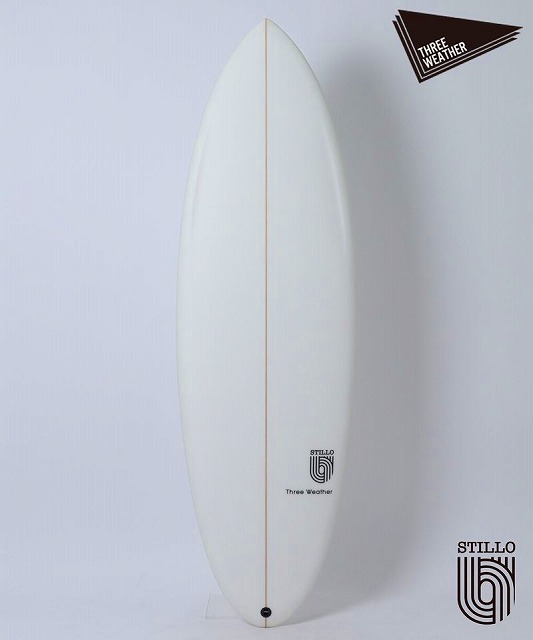 White surfboard standing upright against a light background with a vertical stringer and branding logos near the lower part.