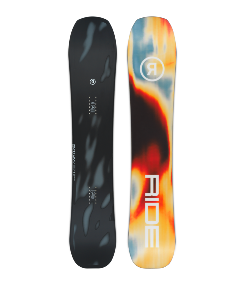 Pair of snowboards standing upright side by side: dark matte left board with subtle gray pattern and small logos, and a colorful tie-dye right board with a large white RIDE/brand mark.