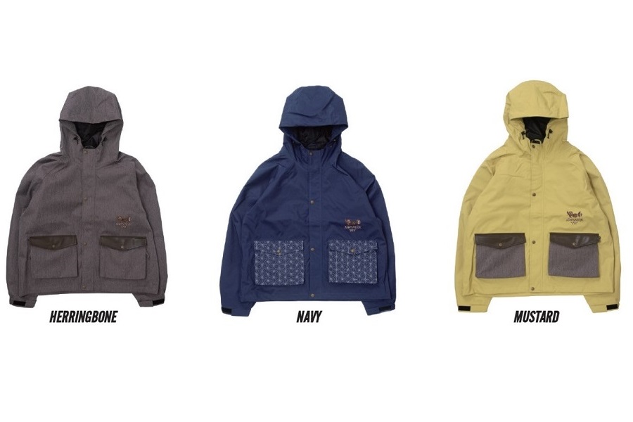 NOMADIK3 - SHOP NEWS | ムラサキスポーツオンラインストア 通販 Gray hooded jacket with two large front pockets and black cuffs, labeled Herringbone