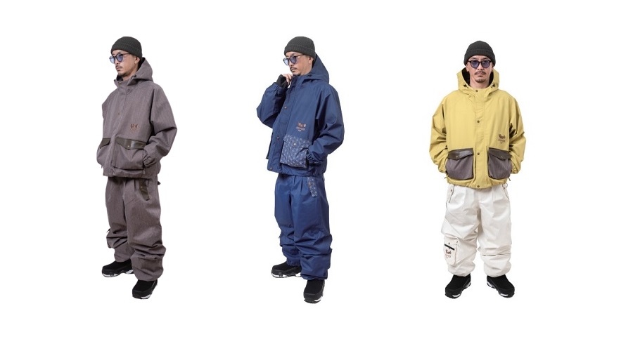 NOMADIK7 - SHOP NEWS | ムラサキスポーツオンラインストア 通販 Three men modeling color‑coordinated winter snowsuits: brown on the left, blue in the middle, yellow on the right, each with hoods and cargo pockets.