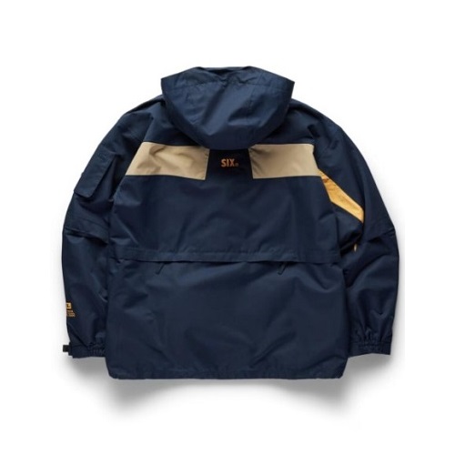 Navy windbreaker with a beige horizontal panel across the back and a hood, shown from the rear.
