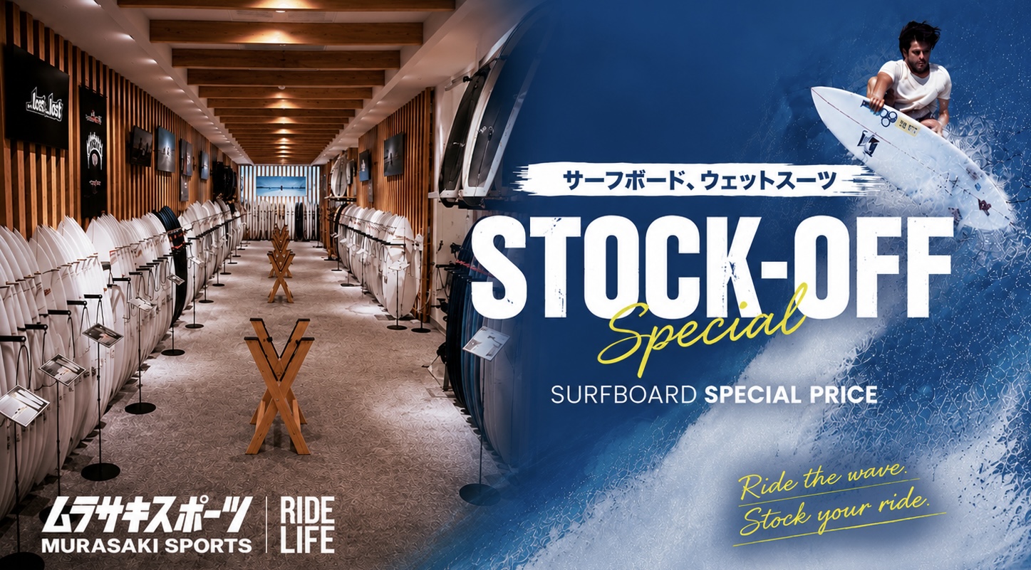 Inside a surfboard shop with rows of white boards on racks, leading to a back display; promotional text for a stock-off sale visible on the right side.