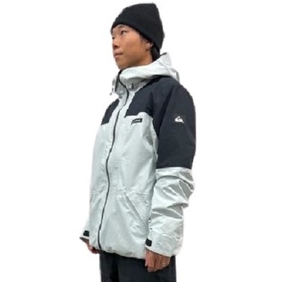 Person in profile wearing a light gray and black hooded outdoor jacket and a black beanie.