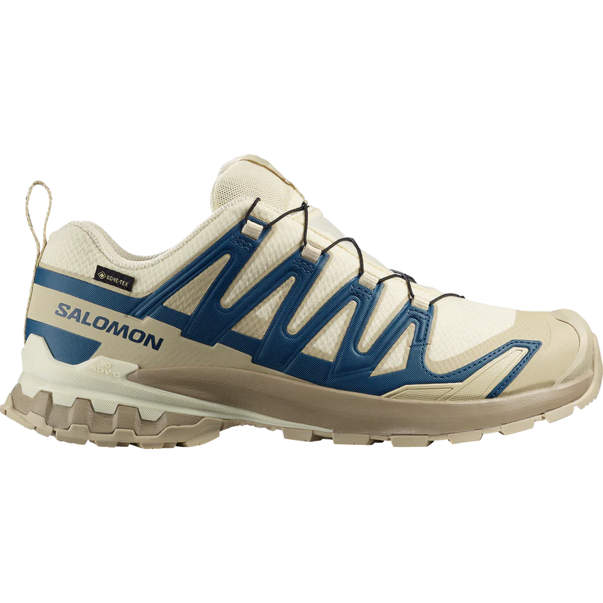 L47987500_0_GHO_XAPRO3DV9GTXTransparentYellow_GibraltarSea_Bogpng - SHOP NEWS | ムラサキスポーツオンラインストア 通販 Salomon trail running shoe in beige with blue overlays and rugged outsole.