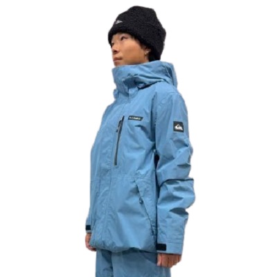Side view of a person wearing a light blue weatherproof jacket and a black knit beanie.